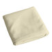 A folded ivory rectangular cloth table cover.