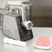 A Galaxy meat grinder attachment next to an aluminum food pan filled with meat.