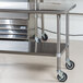 An Advance Tabco stainless steel work table with undershelf and casters.