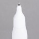 A close-up of a white Bic Wite-Out Shake 'n Squeeze pen with a silver tip.