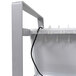 A white metal shelf with a cord attached to it.