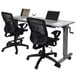 A Luxor adjustable height flip top nesting table with two laptops on it next to a black office chair with wheels.