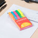 A package of Universal chisel tip pocket highlighters in assorted fluorescent colors on a paper.