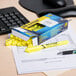 A box of Avery Hi-Liter Fluorescent Yellow Highlighters on a desk with one yellow highlighter on top.