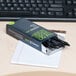 A box of Universal One black medium point gel pens on a desk with a piece of paper.