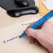A hand writing "Avery 8886 Marks-A-Lot" in blue on an envelope.