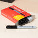 A box of Universal black fine point permanent markers.