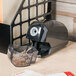 A black Universal electric pencil sharpener on a wood desk.