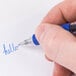 A hand writing "hello" in blue with a Universal One blue gel pen.