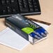 A box of Universal One blue medium point gel pens on a desk.