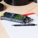 A box of Universal One black fine point retractable ballpoint pens on a table.