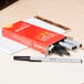 A box of Universal Economy Black Oil-Based Ballpoint Stick Pens on a desk.