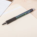 A Universal black medium point gel pen on a piece of paper.