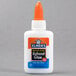 An orange and white bottle of Elmer's Liquid School Glue with a white cap.