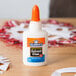 A white bottle of Elmer's white liquid school glue on a table.