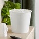 A white disposable paper ice bucket filled with ice cubes.