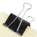 A black Universal large binder clip on lined paper.