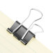 A pair of black Universal binder clips on a piece of paper.