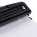 A black Universal 2 or 3 hole punch on a white sheet of paper.