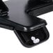 A black Universal countertop 3 hole punch with white paper in it.