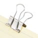 A pair of Universal silver small binder clips on a sheet of paper.