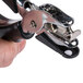 A hand holding a Universal black and silver handheld hole punch with rubber grip.