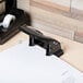 A black Universal 2 hole punch on a table.