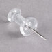 A close-up of a Universal clear plastic push pin with a metal tip.