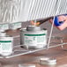 A can of Choice 6 Hour Wick Chafing Dish Fuel with a safety twist cap being lit with a lighter.
