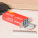 A Universal red box of staples on a table.