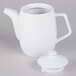 A white Tuxton TuxTrendz teapot with a lid.