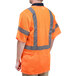 A person wearing a Cordova orange high visibility safety vest with reflective stripes.