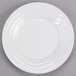 A close-up of a Tuxton TuxTrendz Sandbar bright white china fruit dish on a gray surface.