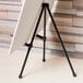 A black steel Universal tabletop easel holding a white board.