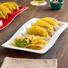 A Tuxton bright white china plate with a taco on it.