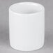 A Tuxton bright white ceramic sugar packet holder on a grey surface.