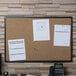 A Universal cork board with papers pinned to it.