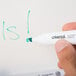 A hand using a Universal Chisel Tip dry erase marker to write on a white board.