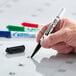 A hand using an Avery Marks-A-Lot pen to write on a calendar.