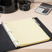 A table with a binder using Avery Big Tab clear dividers with yellow paper inside.