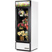 A white True refrigerated glass door floral case with flowers inside.