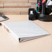 An Avery white binder sitting on a desk.