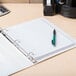 A white Avery Durable View Binder with a pen on it.