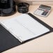 A black binder with Avery Ready Index white table of contents dividers on a table with a calculator.
