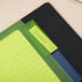 A green file folder with yellow Avery Big Tab dividers on top of it.