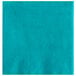 A teal beverage napkin with a white spot.