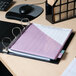 An Avery black durable view binder with a purple cover on a desk with a pen.