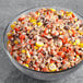 Chopped REESE'S PIECES® Ice Cream Topping in a bowl on a table.