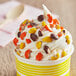 A cup of ice cream with Chopped REESE'S PIECES® candy on top.