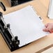 A person's hand holding Avery Premium Collated Legal Exhibit Dividers with a table of contents page.